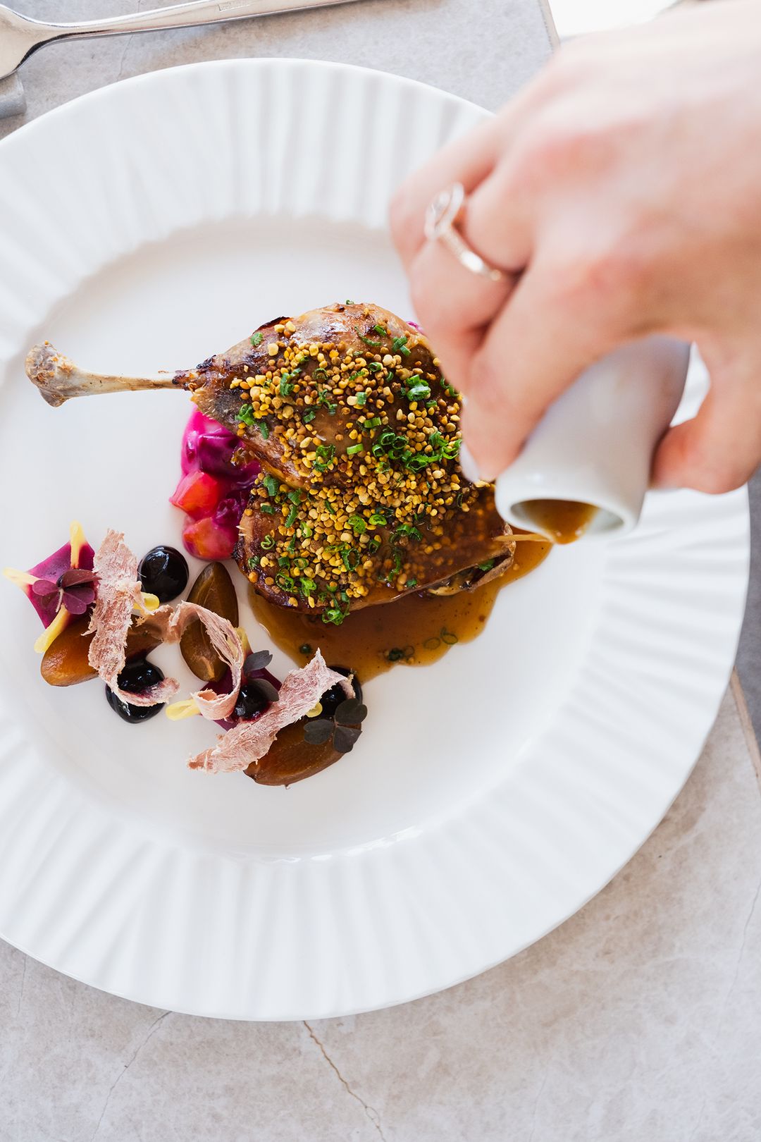 Duck leg being finished with sauce at the table, Przystań & Marina