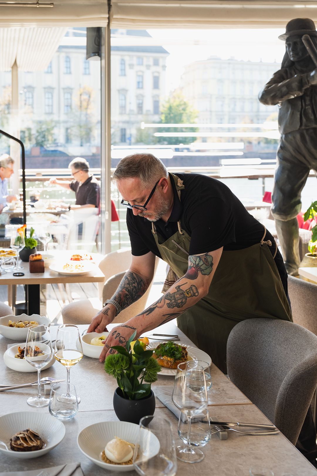 Przystań & Marina team member setting a table in the dining room